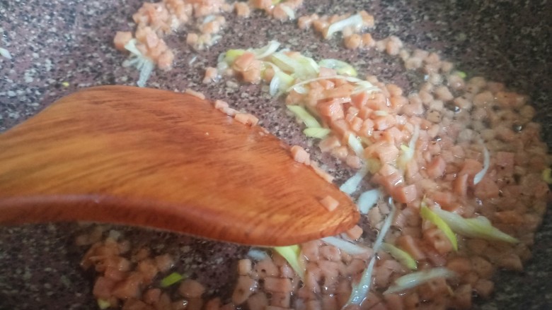 酱油蛋炒饭,再放入葱花,炒出香味。如果先放葱花再放火腿,葱花容易炒焦