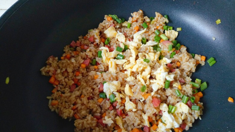 酱油蛋炒饭,倒入鸡蛋,加入剩下的葱碎翻炒片刻即可