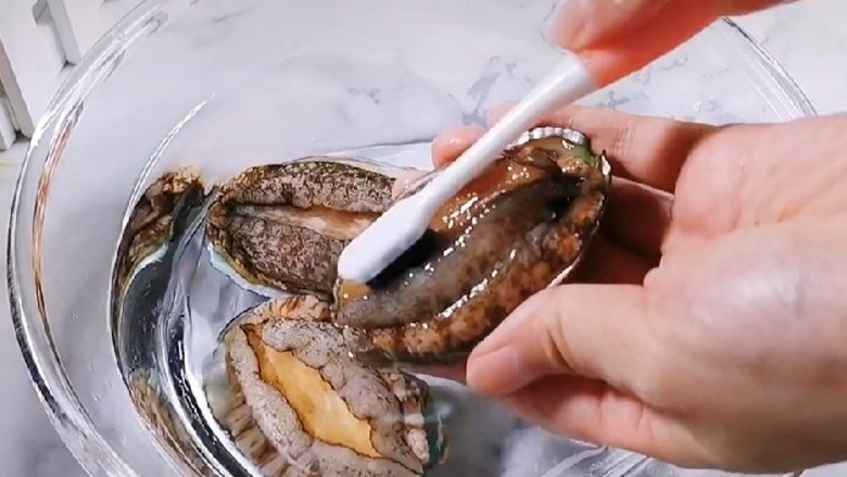 鲍鱼海鲜粥,将买来的鲍鱼用牙刷清洗干净,去除内脏