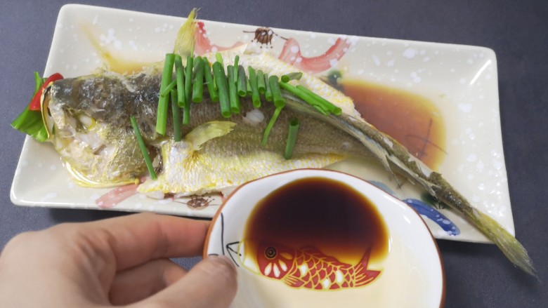 清蒸黄鱼,蒸鱼豉油倒出2题更量(鱼鼓油买的方便,每个品牌盐味有差异,使用前试咸度作调整用量),从碟子边缘一圈倒让之与原汤鱼汁融合汤色漂亮,切记不要从鱼背上开始浇,猜猜为什么