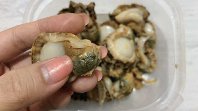 扇贝炒鸡蛋,扇贝肉提前清水洗净,取出内脏部分。(也就是指尖所指黑色的部分)