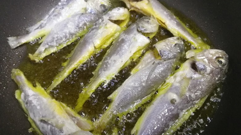 香辣小黄鱼,油温五成热,放入小黄鱼,文火煎3分钟