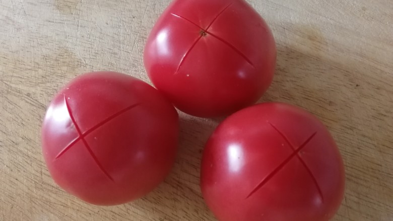 番茄烧冬瓜,柿子顶部切十字花刀,开水里烫半分钟。