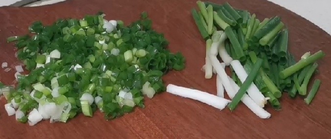 小葱拌豆腐,拿少许的葱切成葱段,再把剩下的葱切成葱花