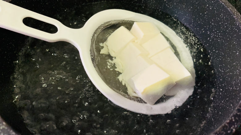 小葱拌豆腐,大火烧开水,直接把豆腐装漏勺里,放入锅中