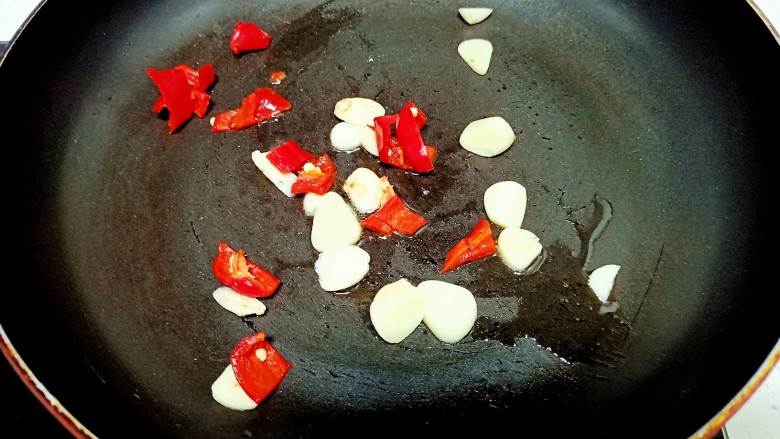 猪肉炒小白菜,锅中放入少量油炒香蒜瓣和红椒