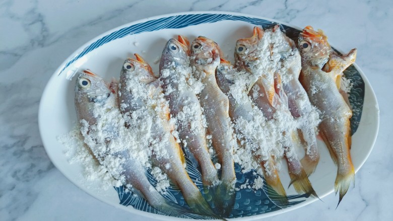 香辣小黄鱼,清理好的<a style='color:red;display:inline-block;' href='/shicai/ 352'>小黄鱼</a>裹一层面粉,轻轻拍一层即可,多余的面粉抖掉。