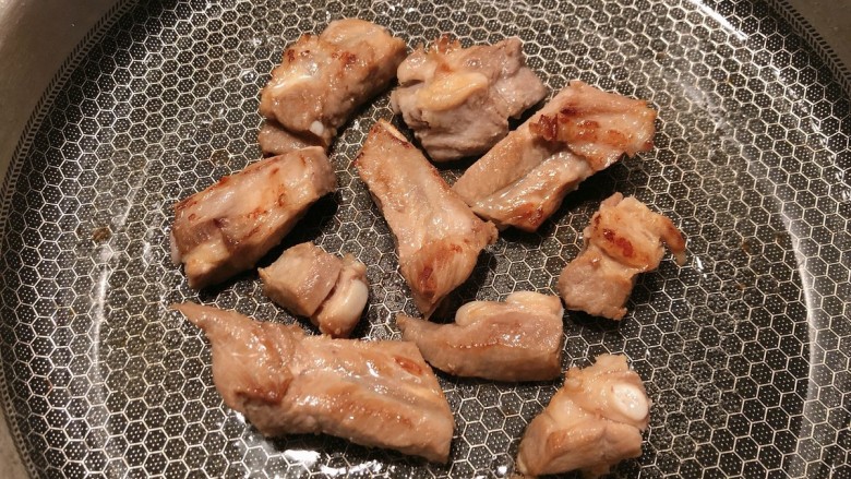 土豆排骨焖饭,热锅烧油,排骨煎至两面金黄