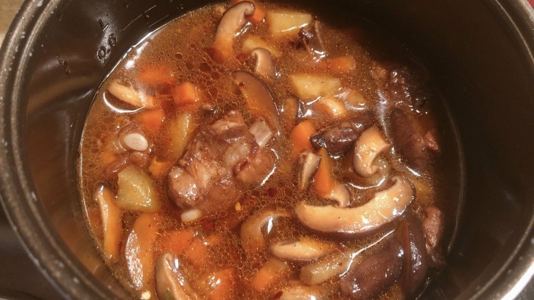 土豆排骨焖饭,倒入食材和汤汁,汤汁没过所有材料
