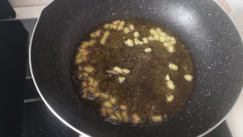 香辣小黄鱼,炸鱼留下的油适量于锅中加姜粒开火,至闻到香味,姜表面微焦黄