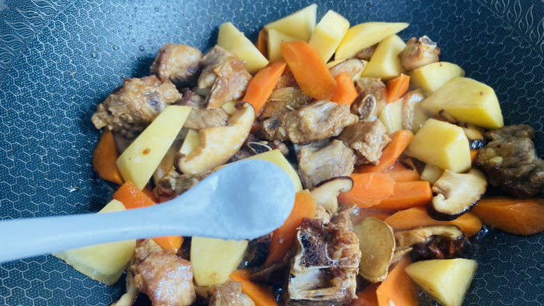 土豆排骨焖饭(电压力锅版),放入香菇、胡萝卜、土豆翻炒片刻,根据个人口味加入适量盐翻炒均匀