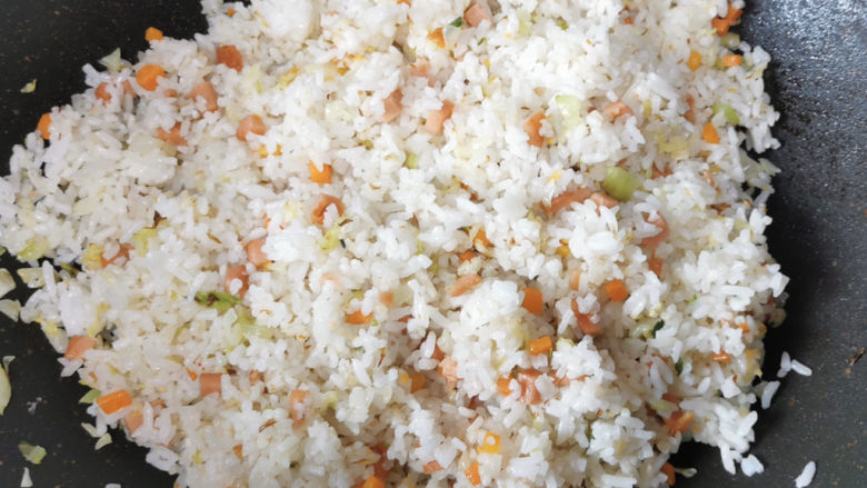 酱油蛋炒饭,加入剩饭,快速翻炒均匀,这时候要开小火翻炒,因为剩饭一般都容易结块,所以要比较长的时间来捯成颗粒。我婆婆有一个小妙招就是沿着锅边淋一小圈料酒,这样炒一会饭结块就很容易炒散开。