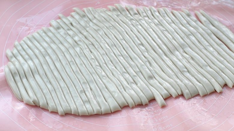臊子面,将面片切成一厘米宽的小条状,然后一条一条的拉长。醒发好的面特别柔软,轻轻一拉就变长了。