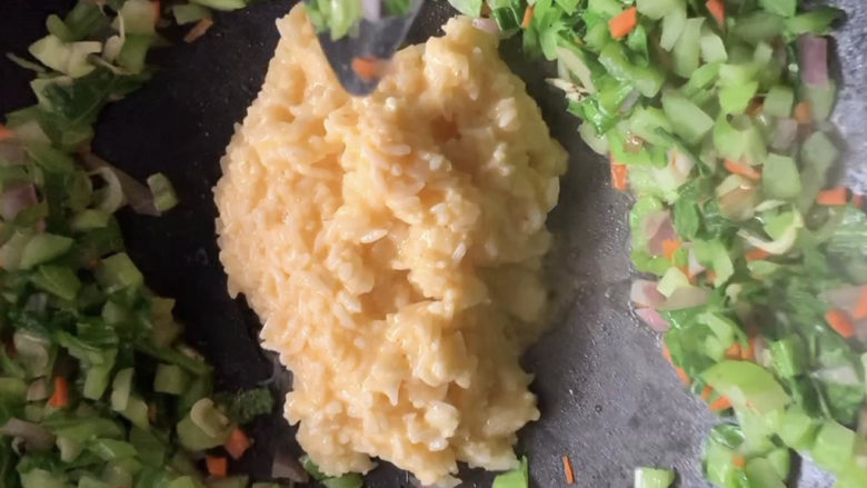 青菜炒饭,将裹着蛋液的米饭放入快炒。