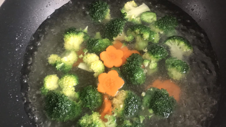 西兰花炒鸡蛋,水中加适量盐和油,烧开下入西兰花和胡萝卜焯水1分钟
