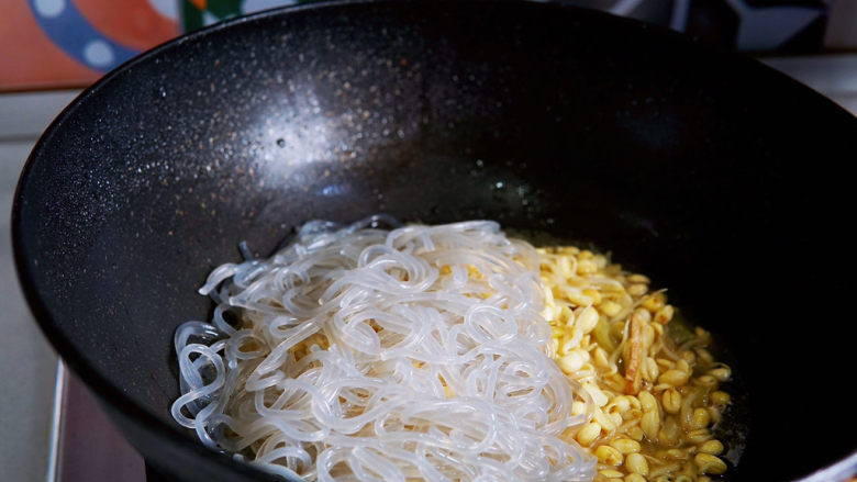 豆芽炒粉条,接着放入红薯粉,翻炒片刻。