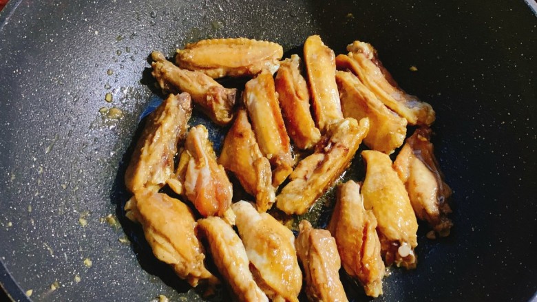 蒜香鸡翅,热油,鸡翅抹去蒜末下锅煎