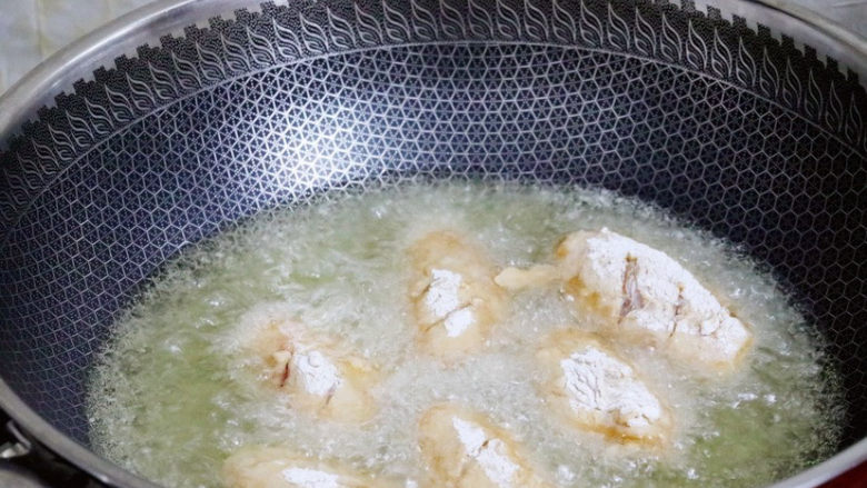 蒜香鸡翅,锅中倒入适量的食用油烧至6成热时,放入鸡翅