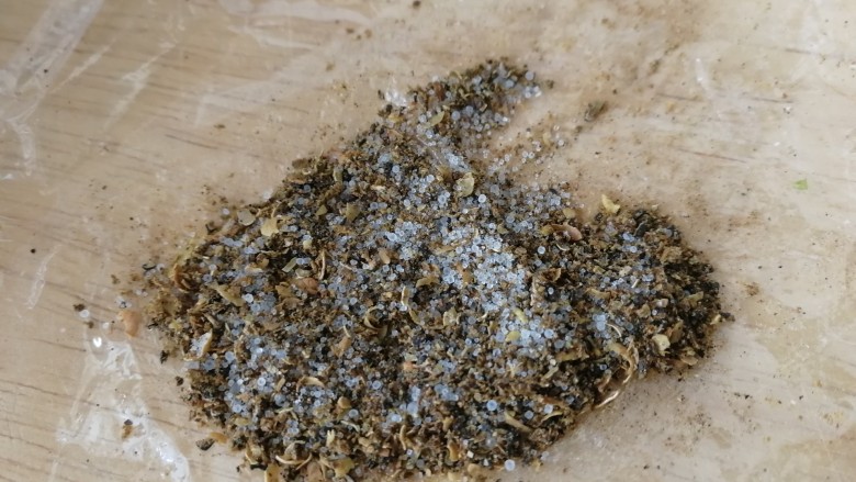 香炸胡瓜鱼,花椒粒和盐放入炒锅,不放油,小火炒香炒酥,包上保鲜膜擀碎。(现炒的香味比较浓郁。)