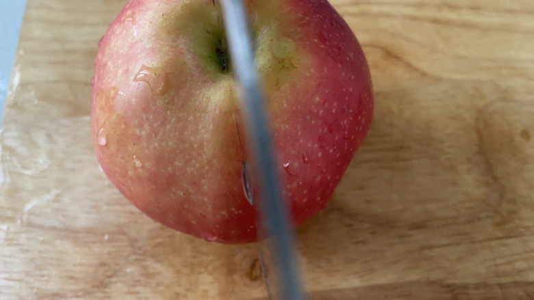 苹果小米粥,把苹果切一半。