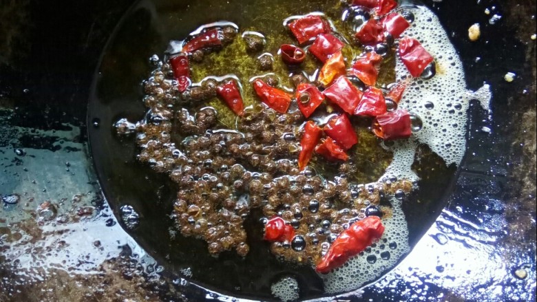 酸豆角炒肉末,炒锅留底油,放干辣椒粒和花椒小火炒香。