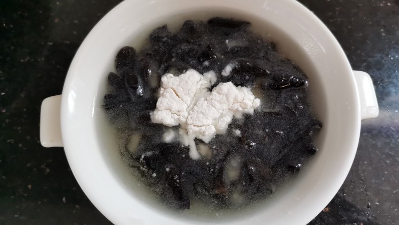 茭白木耳炒肉,泡好的木耳加入少许面粉清洗干净,沥水