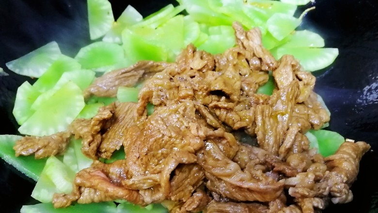 莴笋炒牛肉,倒入牛肉,文火翻炒均匀。