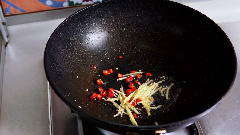 酸豆角炒肉末,锅中底油,放入红椒圈与姜丝煸炒出香味。