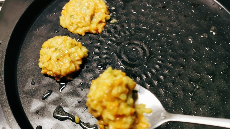 莲藕饼,煎烤机底盘预热刷油,用勺子将莲藕肉馅摊到底盘上,煎制。