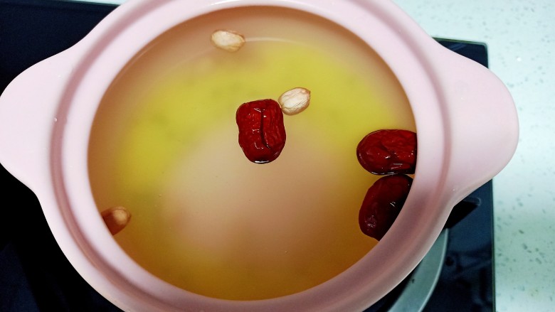 苹果小米粥,锅中放入食量清水 加入淘洗干净的小米 花生 绿豆和红枣 