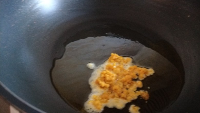 耳光炒饭,锅中倒入适量油烧热，倒入咸蛋黄炒均匀。