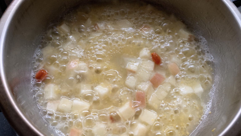 苹果小米粥,米汤达到浓稠即可出锅。