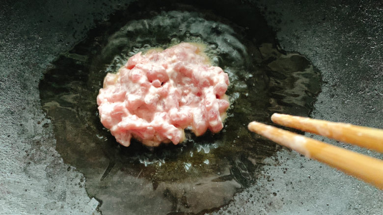 莴笋炒牛肉,将牛肉丝先行下锅,小火用筷子滑散开。