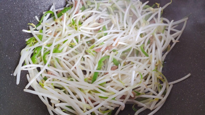 豆芽炒粉条,加入绿豆芽,翻炒至绿豆芽稍稍变软,体积变小