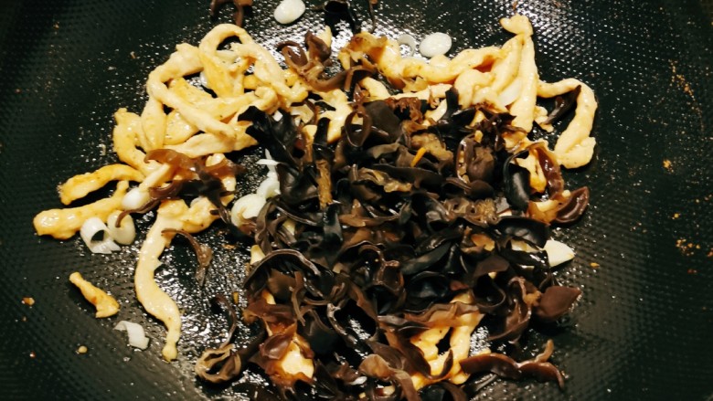 茭白木耳炒肉,放入木耳翻炒。