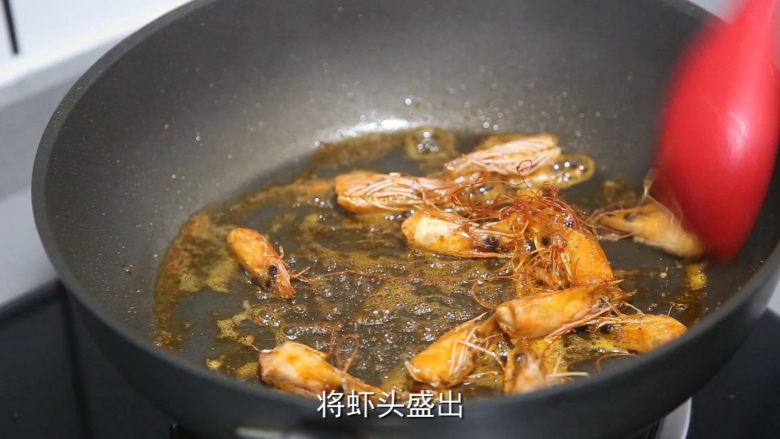 耳光炒饭,锅里烧热油,放虾头翻炒出红油后捞出