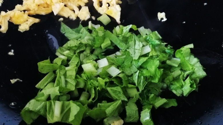 青菜炒饭,把鸡蛋推到锅边,加一点油放入青菜,文火和鸡蛋炒匀。