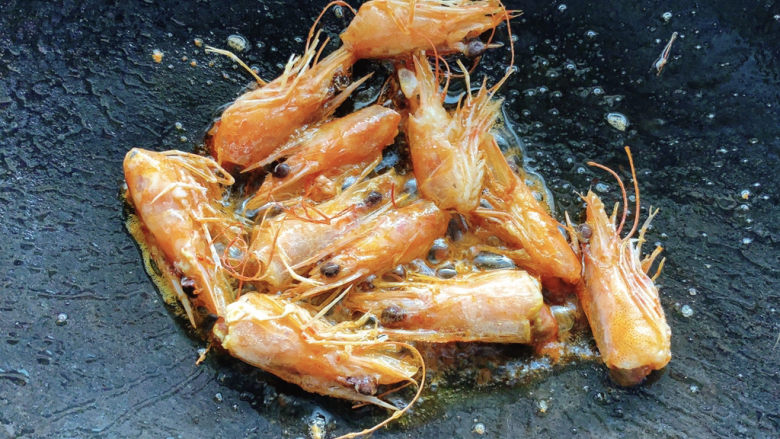 耳光炒饭,热油锅加少许油,将虾头放入。