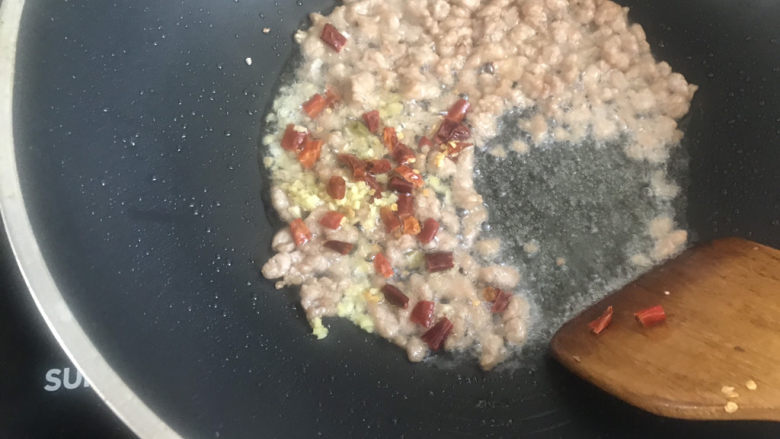 酸豆角炒肉末,下入姜末干辣椒炒香