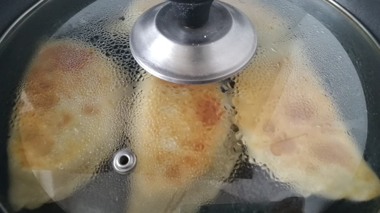 韭菜盒子,盖上盖子,中小火焖1分钟,盒子鼓起就好了。