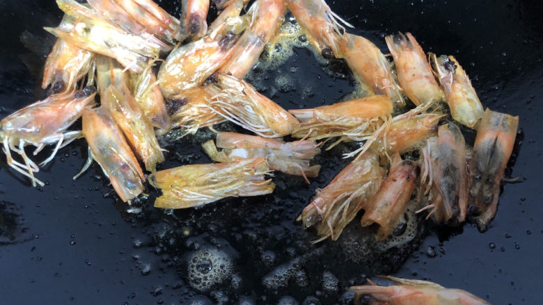 耳光炒饭,热锅冷油下虾头,小火煸炒出油后,挑出虾头丢弃。