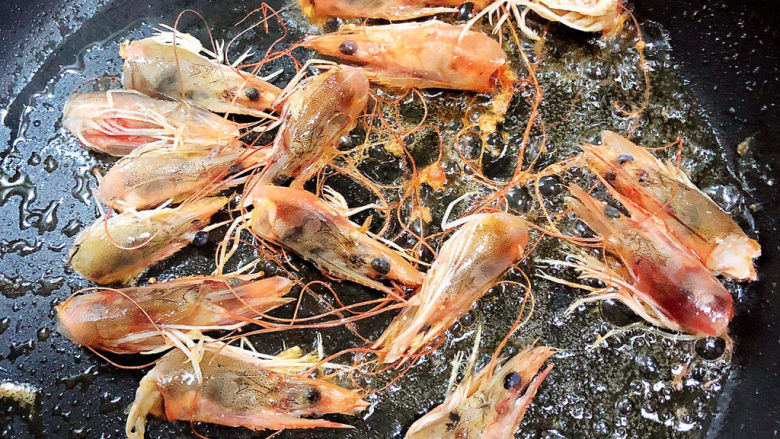 耳光炒饭,锅中倒入油,放入虾头,练出虾油。