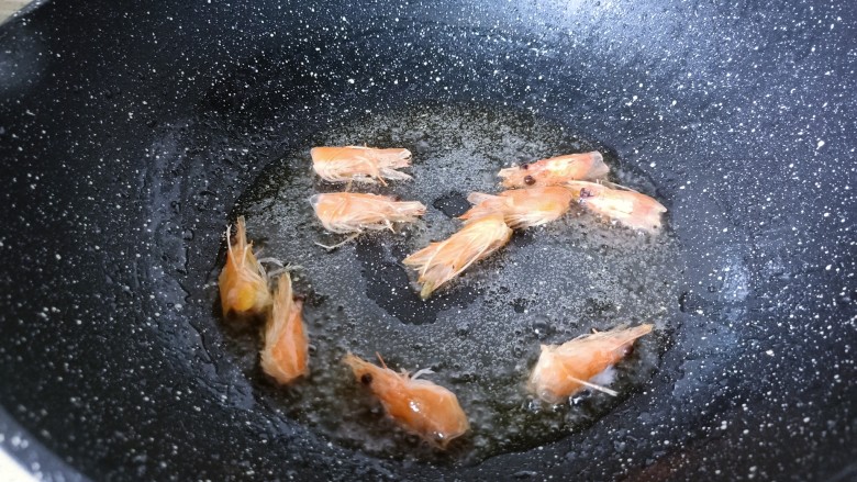耳光炒饭,热锅冷油下虾头炼油,当锅内油呈金黄色后,捞出虾头就不需要了。