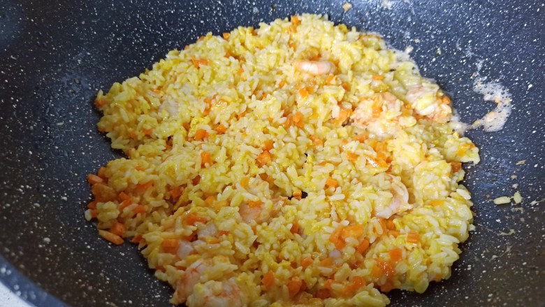 耳光炒饭,加入米饭开大火快速翻炒,翻炒至每一粒米饭都包裹着金黄色的外衣。