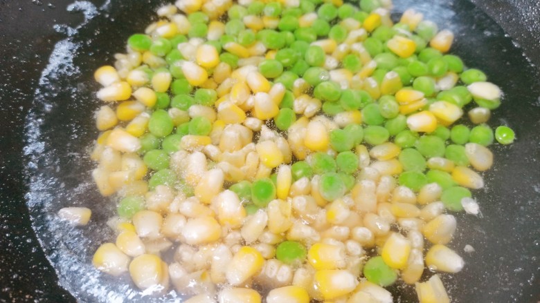 耳光炒饭,锅里烧开水,把玉米粒,豌豆倒入焯水