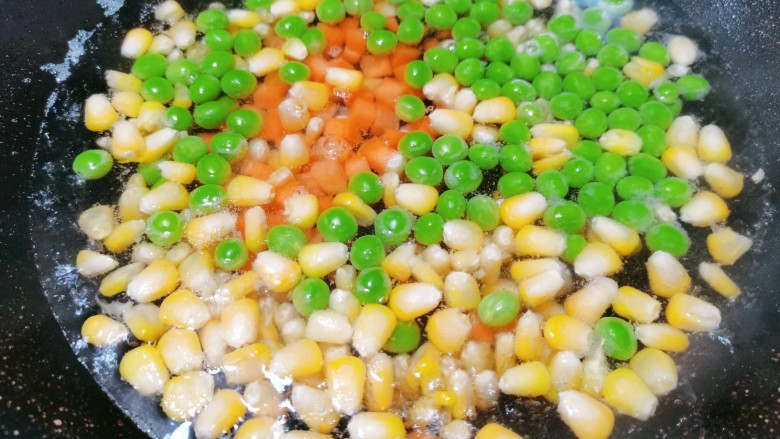 耳光炒饭,两分钟后再把红萝卜丁倒入焯水,焯至豌豆变成鲜绿色