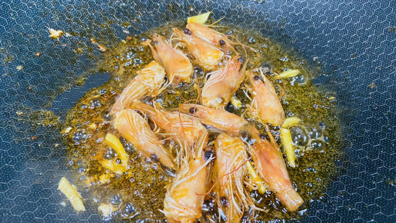 耳光炒饭,起油锅放入姜丝和虾头炒出虾油,然后取出虾头