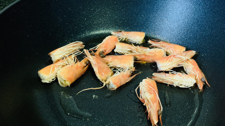 耳光炒饭,锅加食用油,大火热锅,加入虾头,炒出虾油,捞出虾头