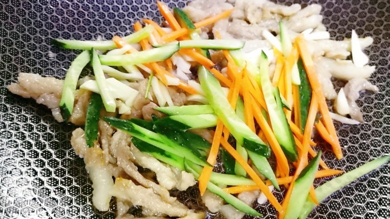 茭白木耳炒肉,加入蒜片爆香 再加入胡萝卜黄瓜丝