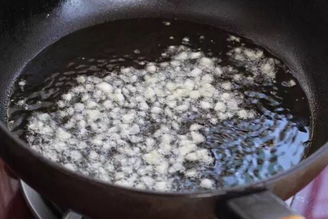 青椒土豆片,锅中倒适量食用油烧至五成热,放入一半的蒜末小火炒出香味。